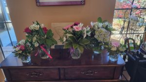 Table of vases of flowers made by our Joy in a vase program volunteers